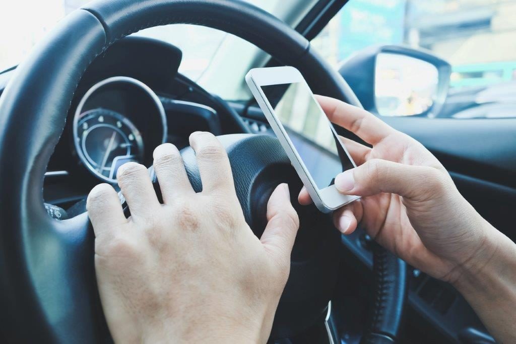 Do you attract demerit points for using a mobile phone whilst driving?